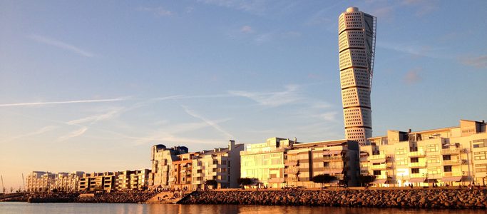 The apartments and Turning Torso sky scraper in Vastra Hamnen Western Harbour at a golden sunset in Malmo Sweden.